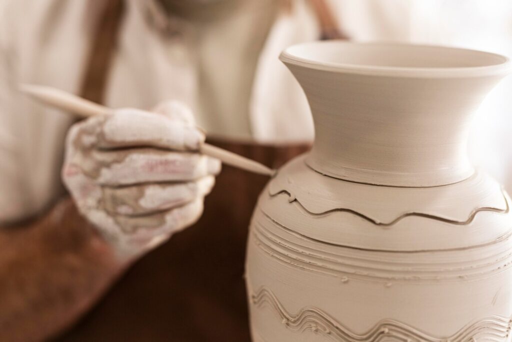Close up hands holding pottery tool 23 2148986298